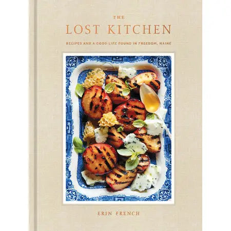 Book cover of 'The Lost Kitchen' with a dish of grilled peaches and cheese.