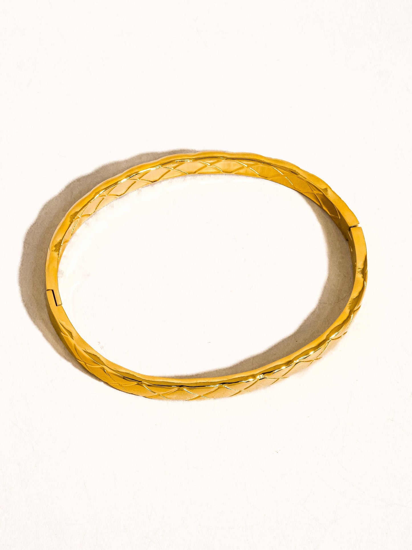 Gold ring with textured design on a white background