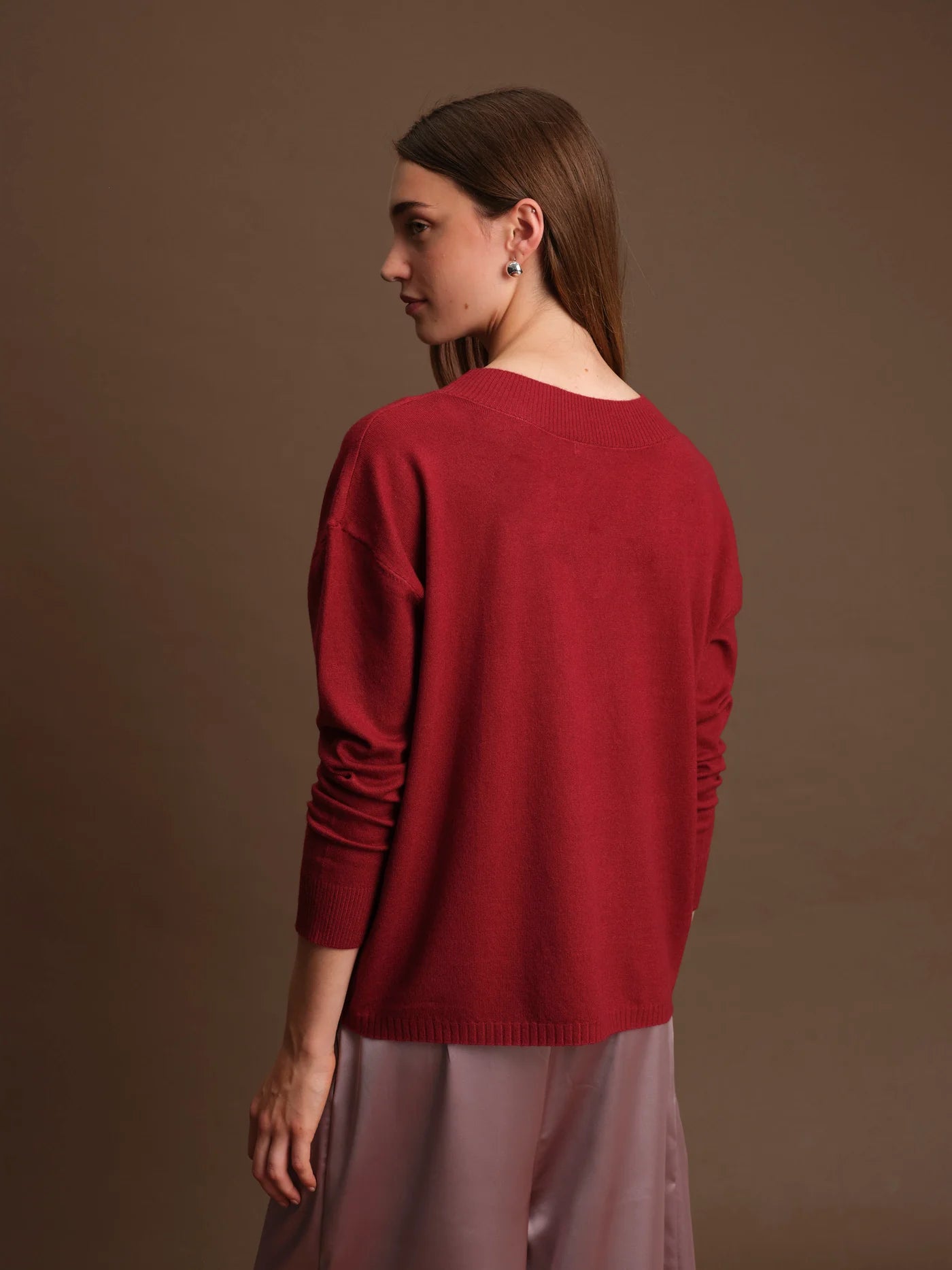 Woman wearing a red sweater against a brown background