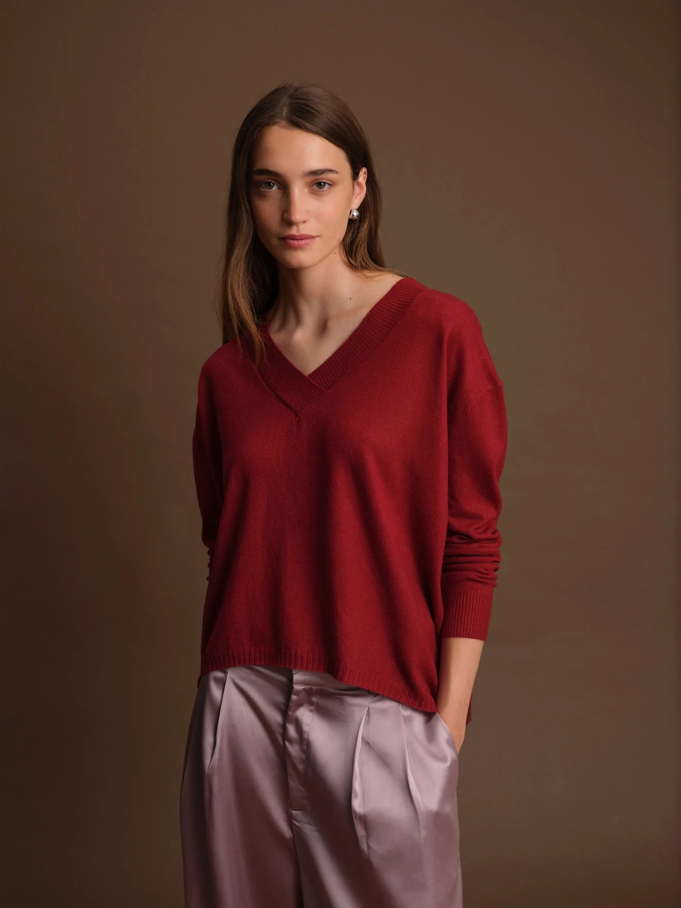 Woman wearing a red sweater against a brown background