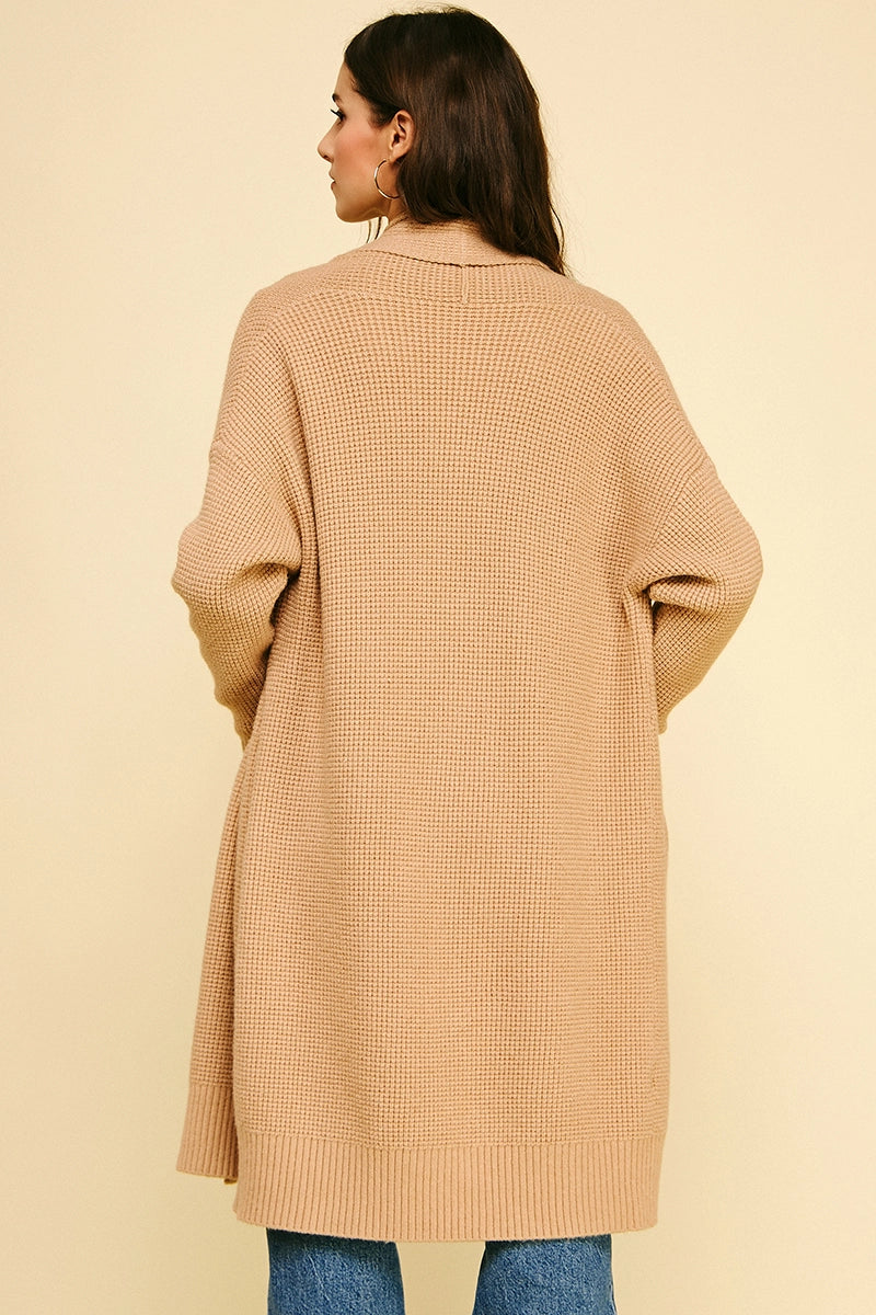 Woman wearing a beige coat on a beige background