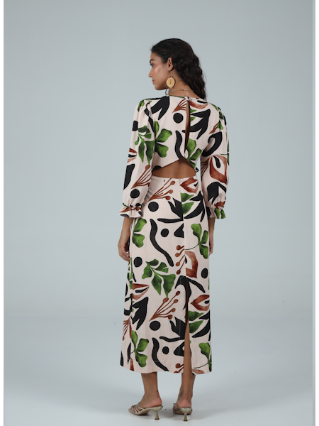 Woman wearing a long-sleeve dress with a colorful abstract pattern on a gray background