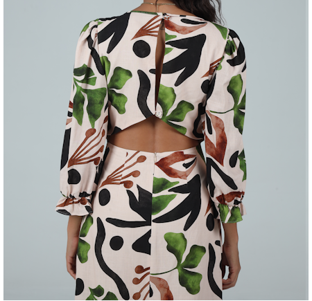 Woman wearing a floral patterned outfit on a plain background
