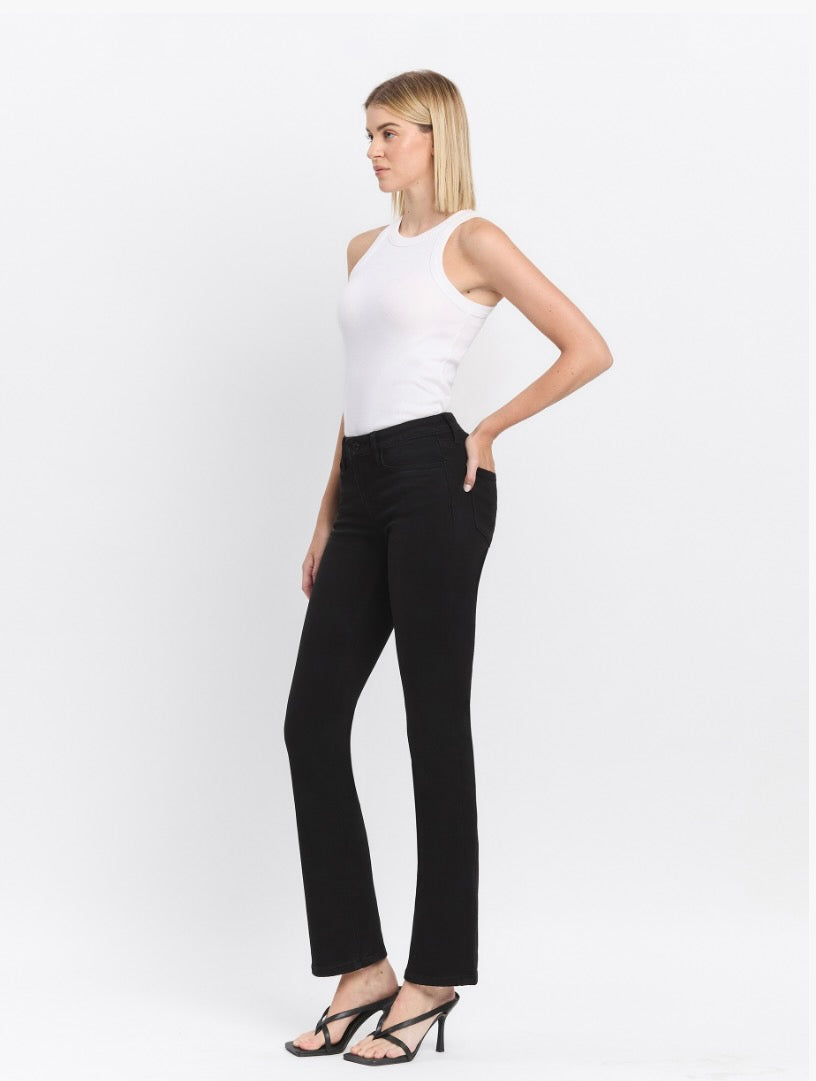 Woman wearing a white sleeveless top and black pants on a white background