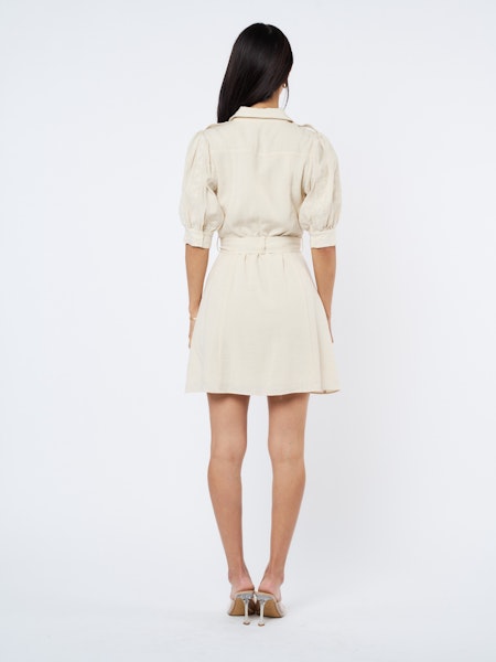 Woman wearing a cream-colored dress on a white background