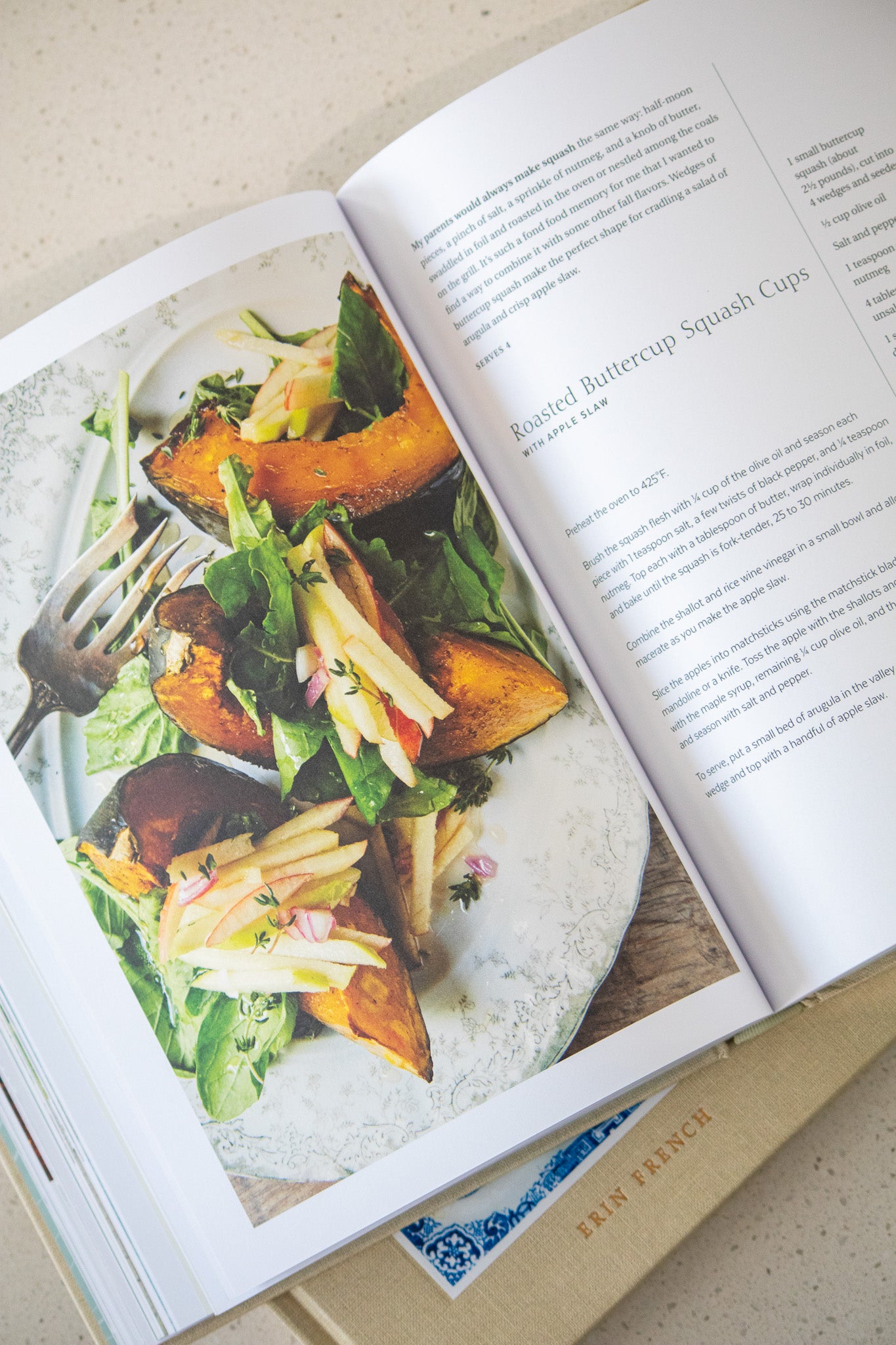 Open cookbook showing a recipe for roasted butternut squash cups with a fork and salad.