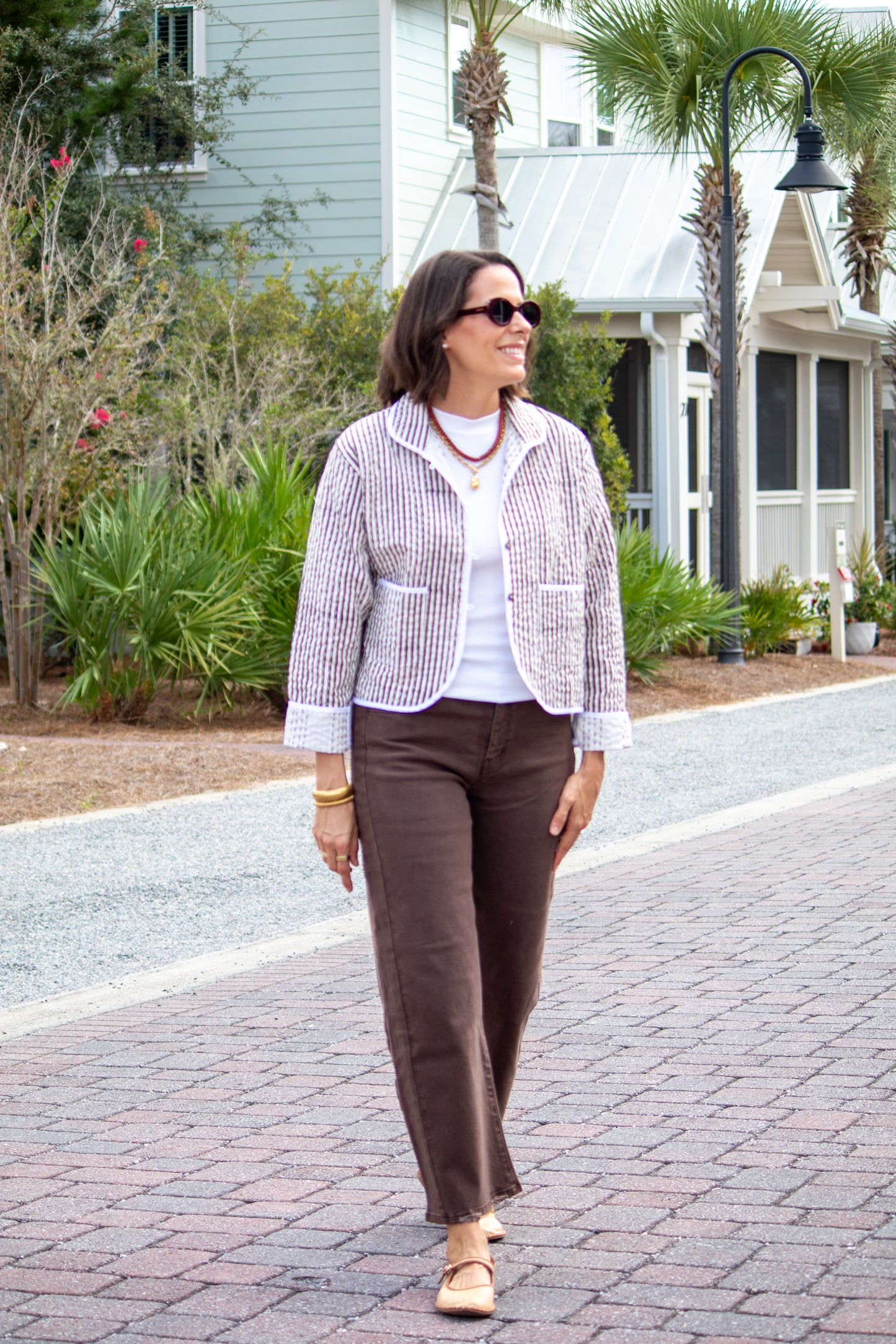 Woman walking on a paved path in a residential area