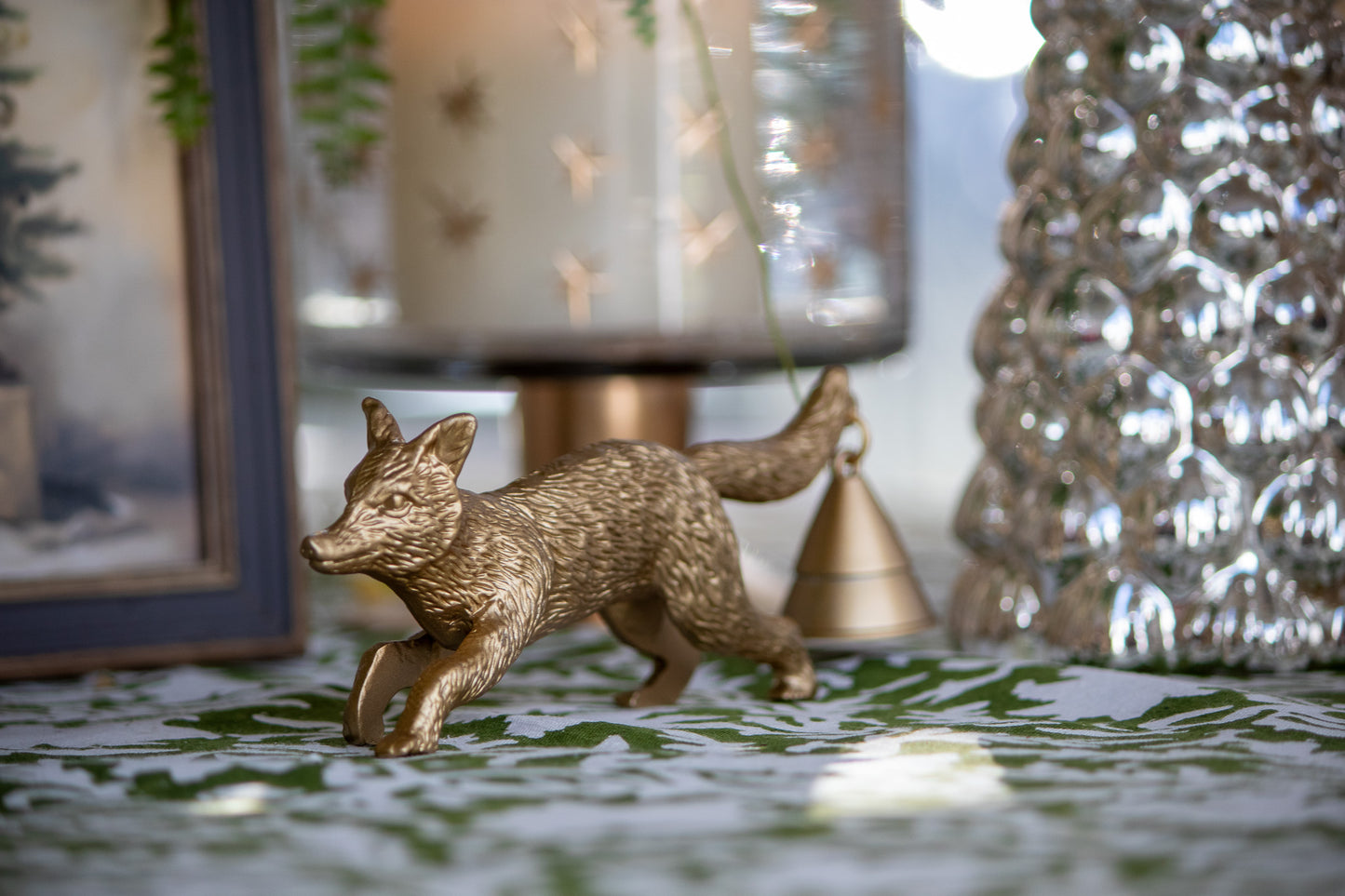 Bronze fox figurine on a decorative surface with a blurred background