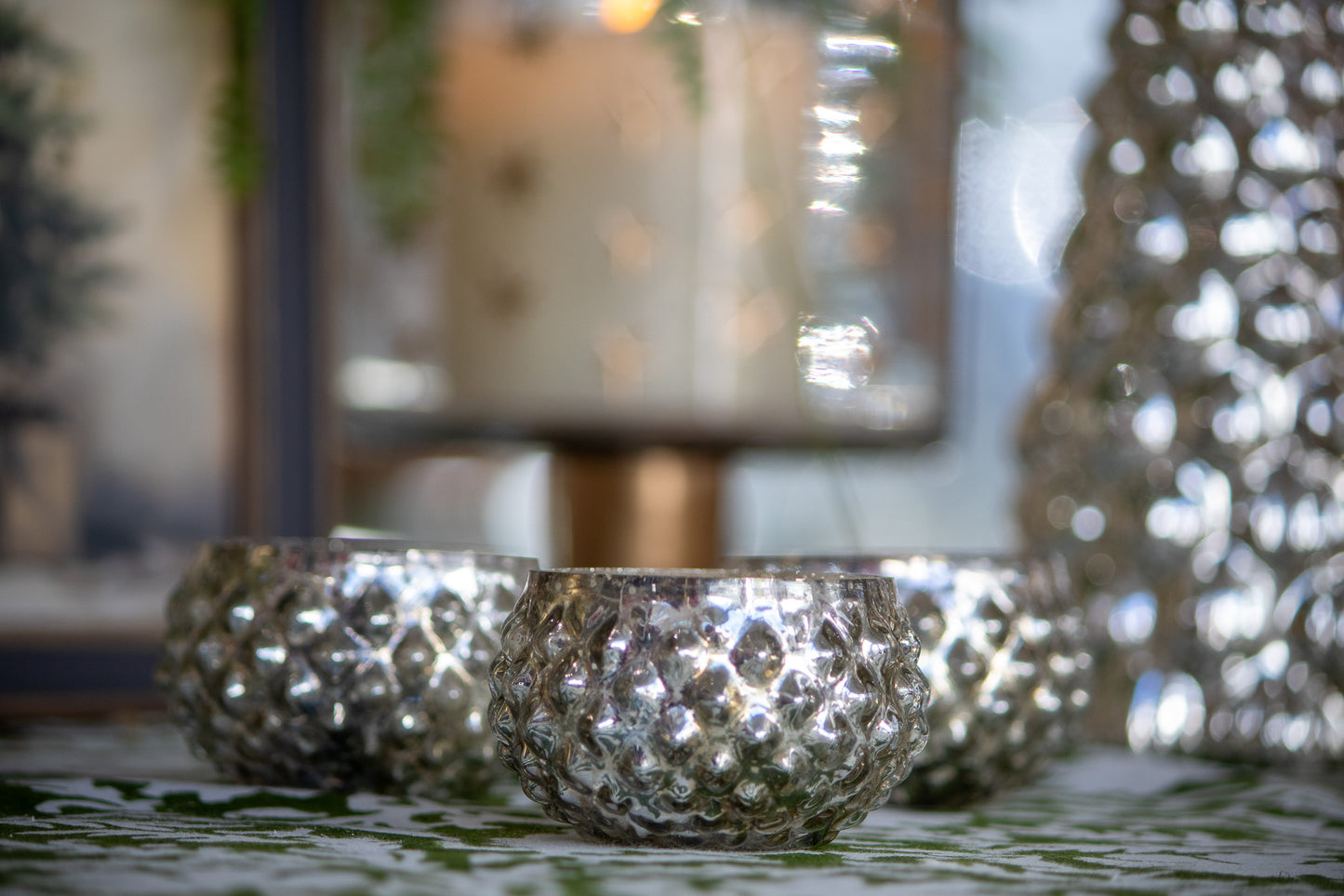 Silver candle holders on a table with a blurred background