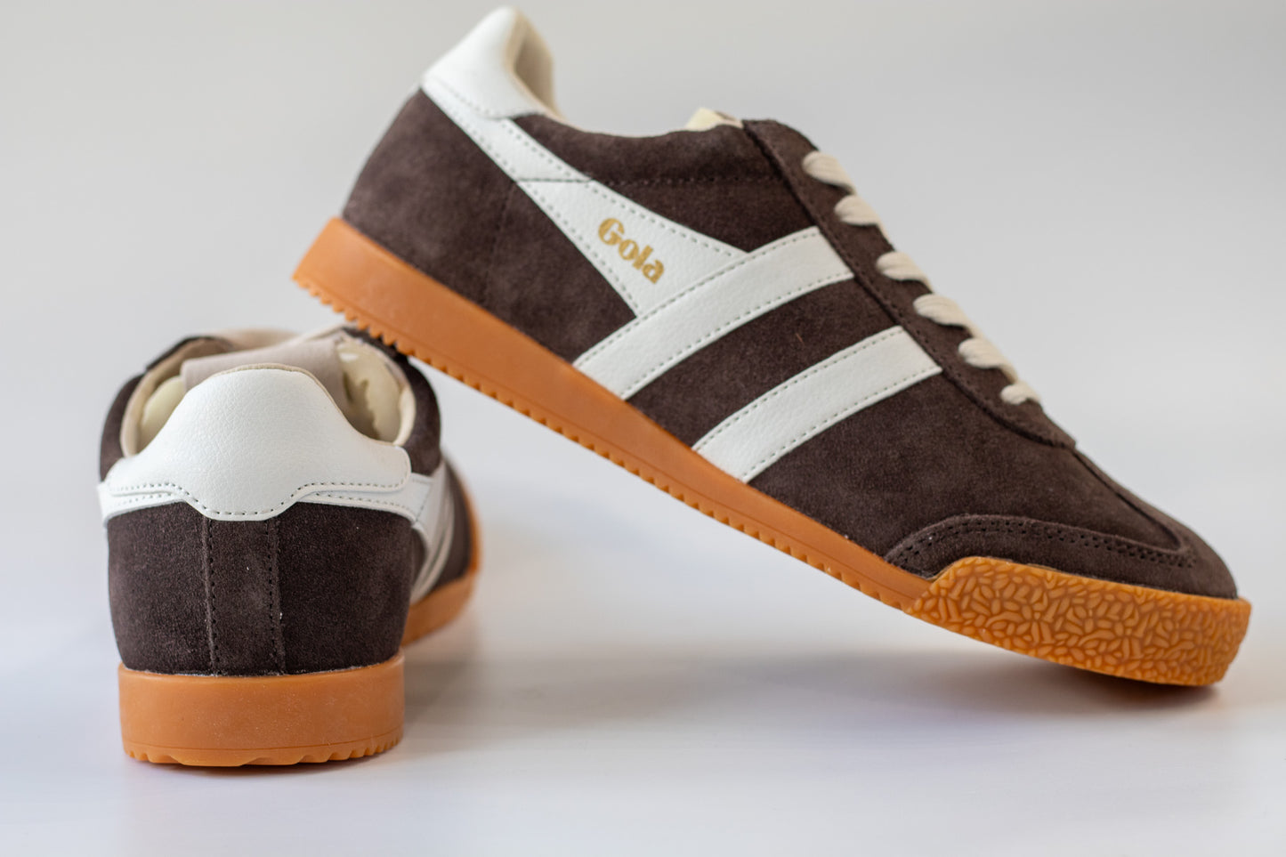Brown and white sneakers with 'Gola' branding on a light gray background
