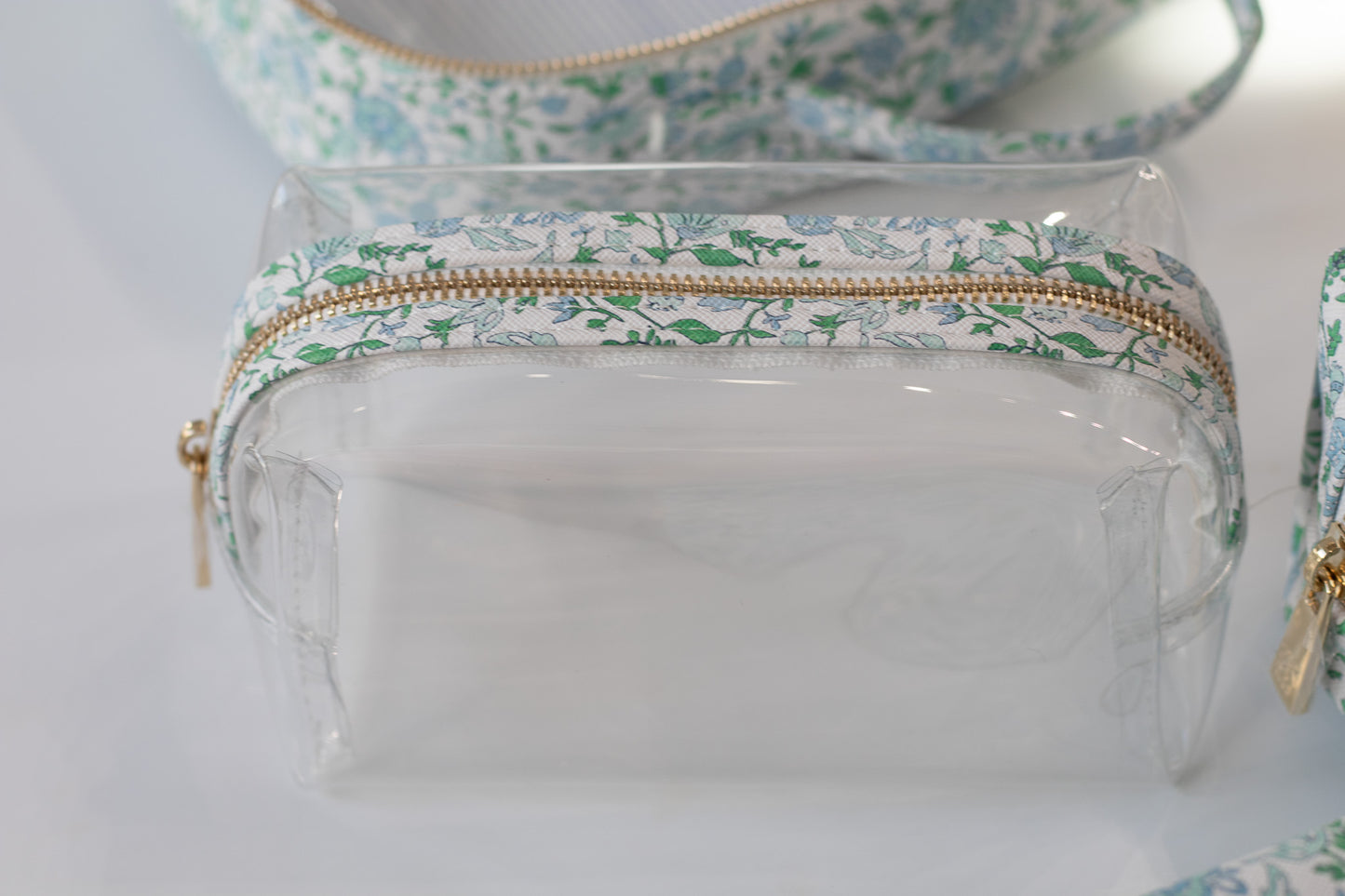 Clear pouch with floral patterned zipper on a light background