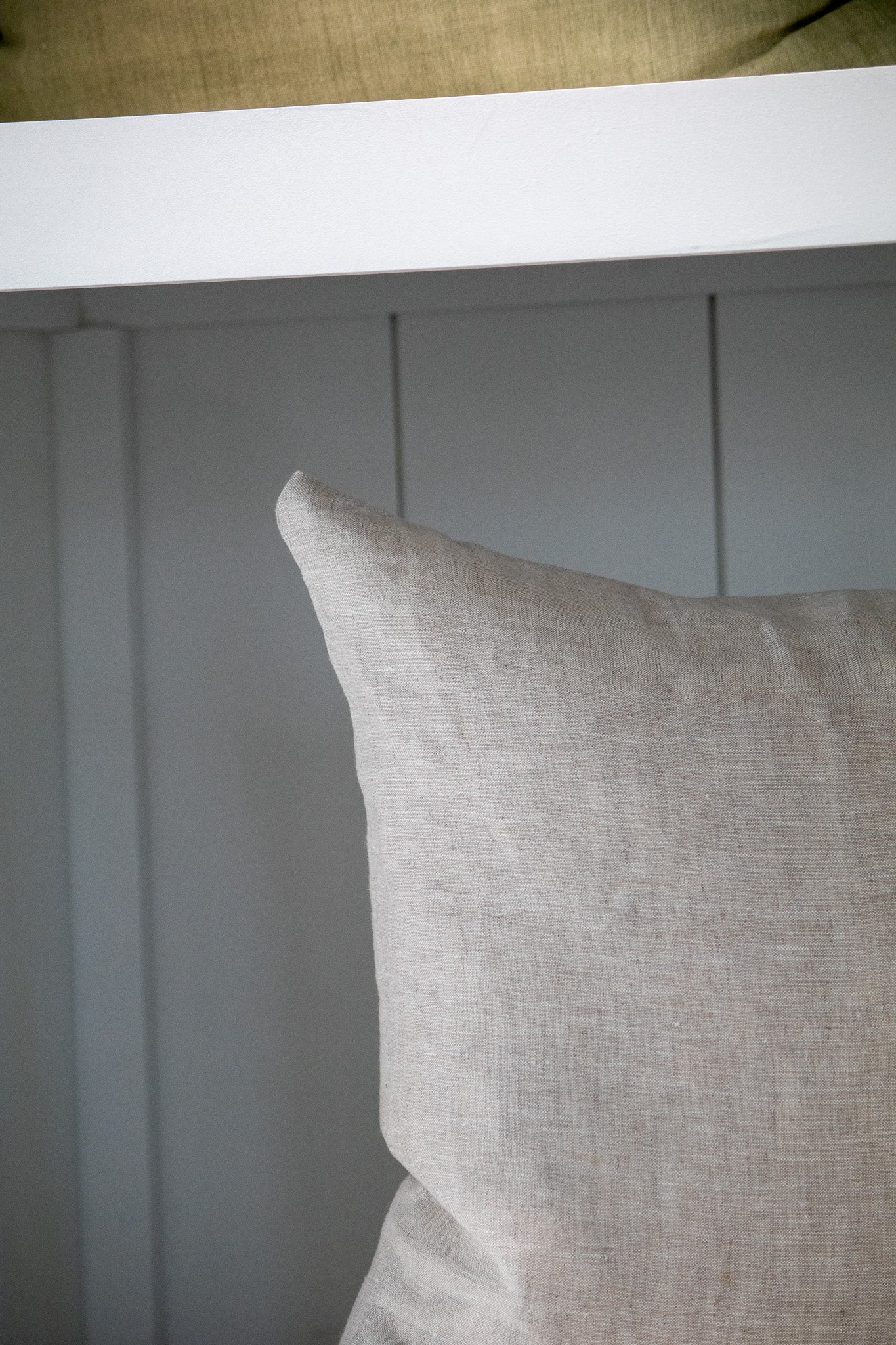 Gray pillow on a white wooden shelf