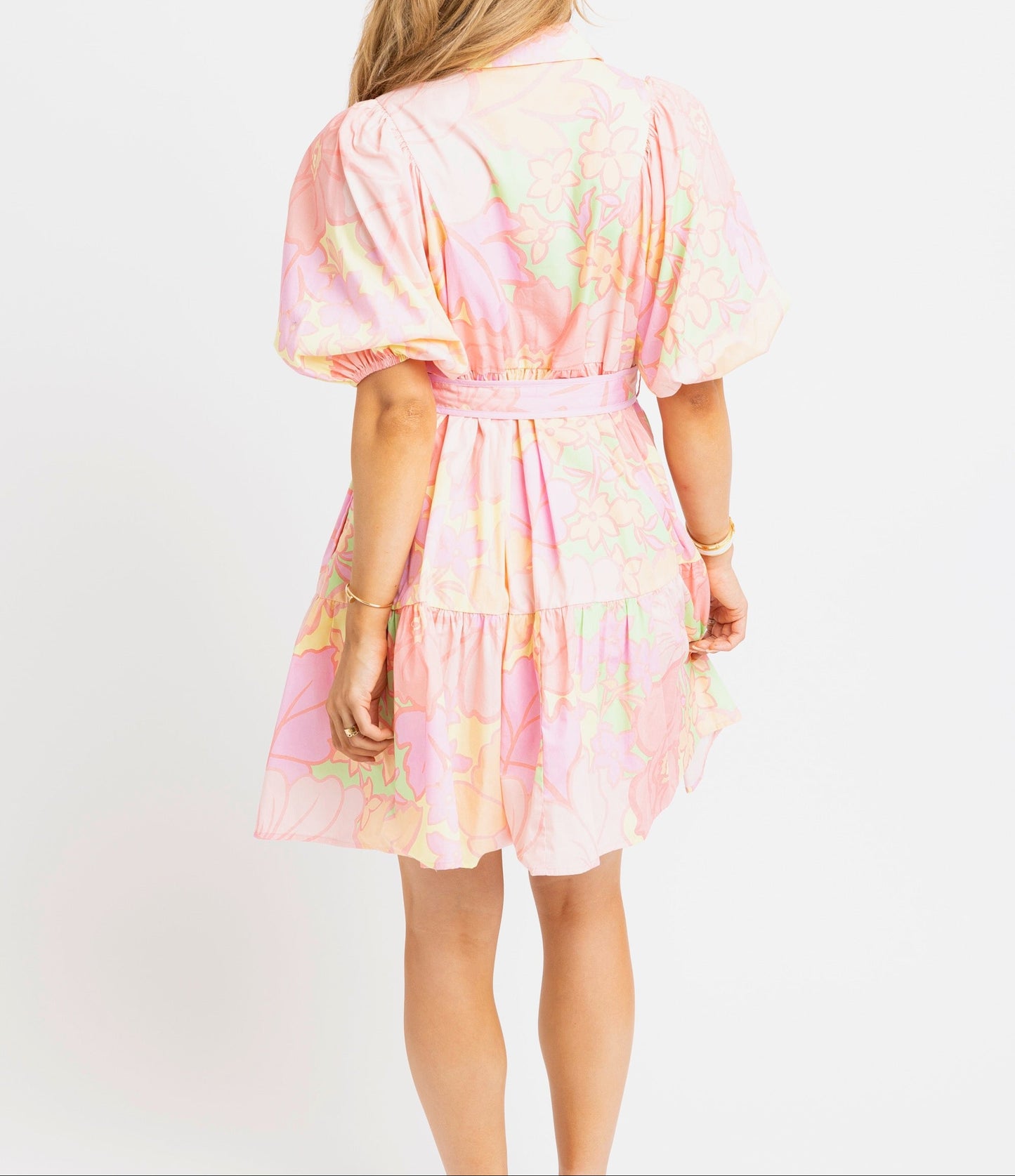 Woman wearing a pink tie-dye dress with a white background