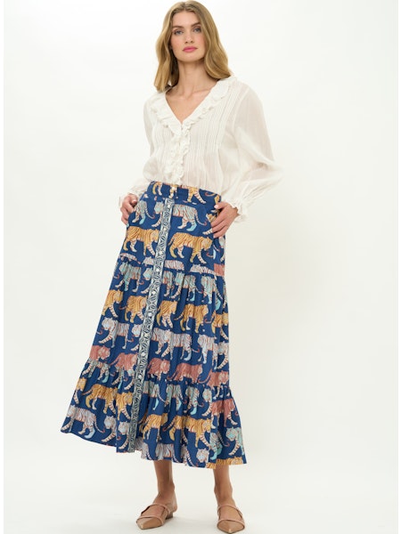 Woman wearing a white blouse and a blue skirt with animal pattern on a white background