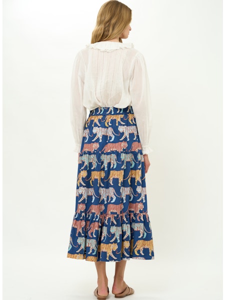 Woman wearing a blue skirt with animal pattern on a white background