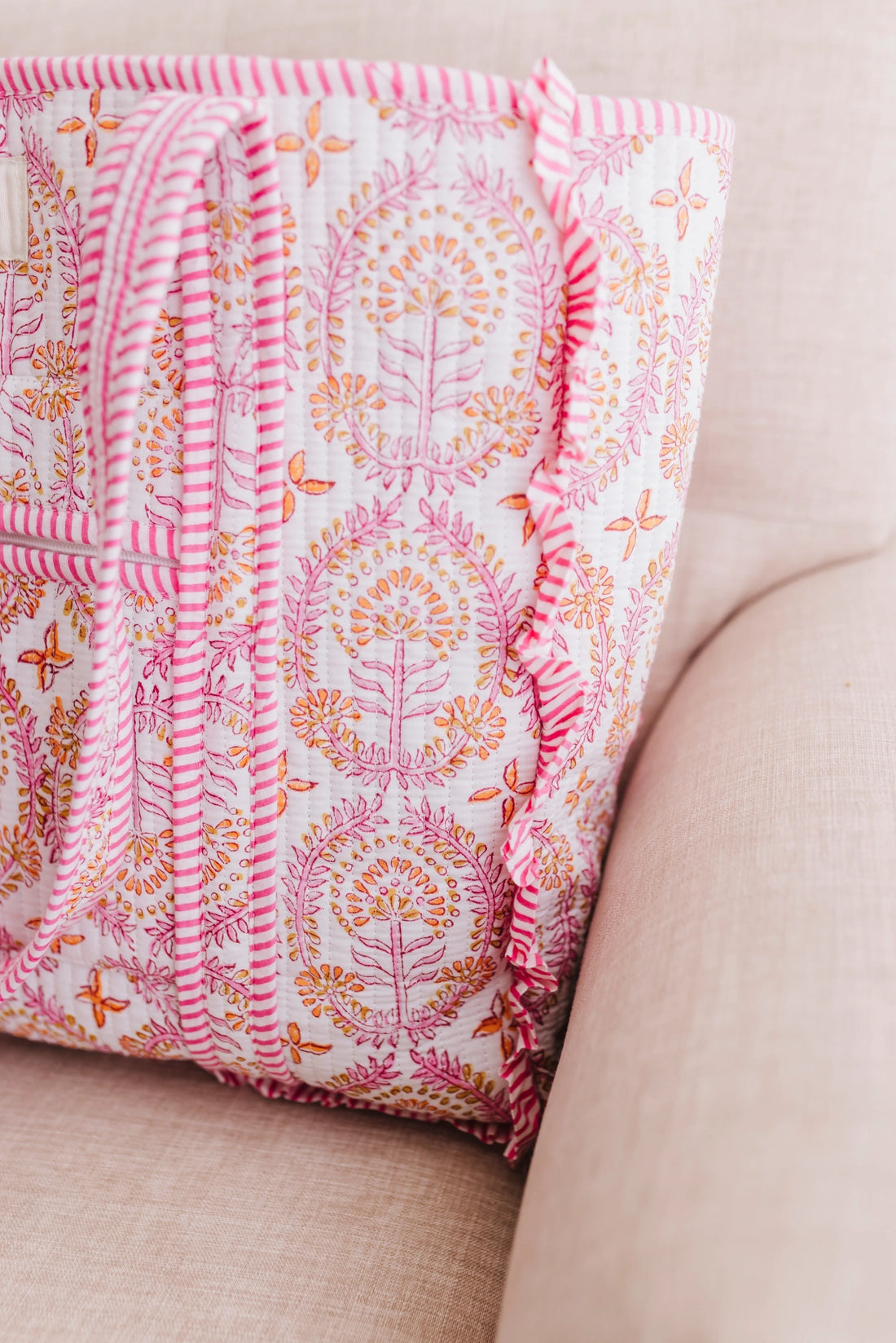 Floral-patterned fabric with pink trim on a beige surface