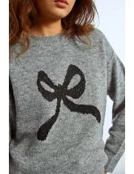 Gray sweater with a black bow design worn by a person
