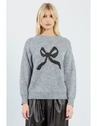 Woman wearing a gray sweater with a black design on a light gray background