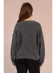 Woman wearing a gray sweater with a plain background