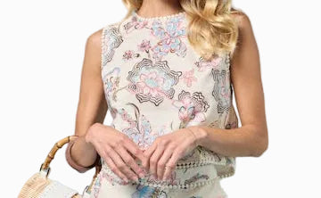 Woman wearing a floral dress holding a handbag against a light blue background