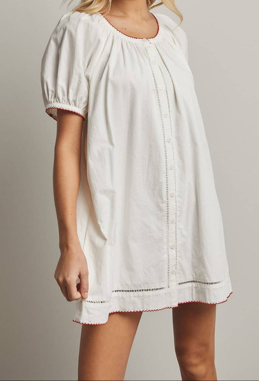 Woman wearing a white dress against a plain background