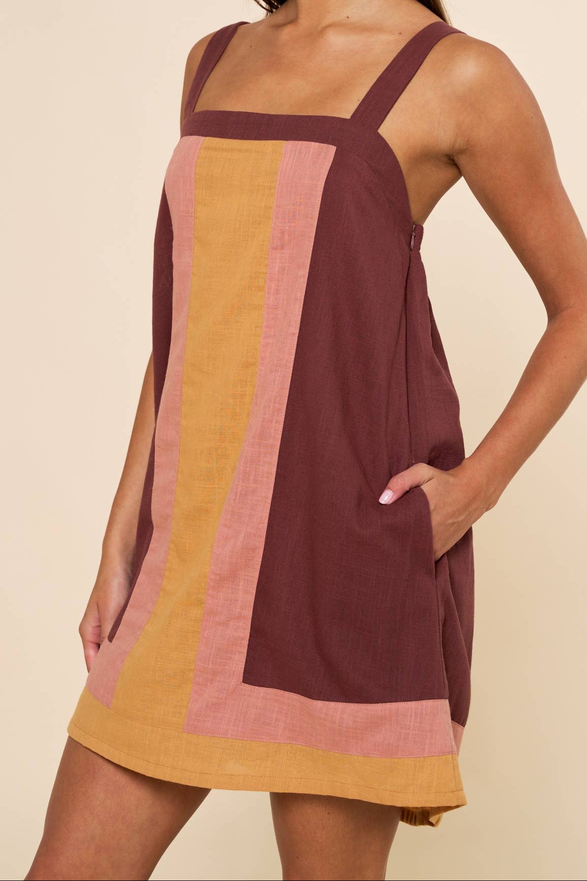 Woman wearing a color-blocked dress with a plain background