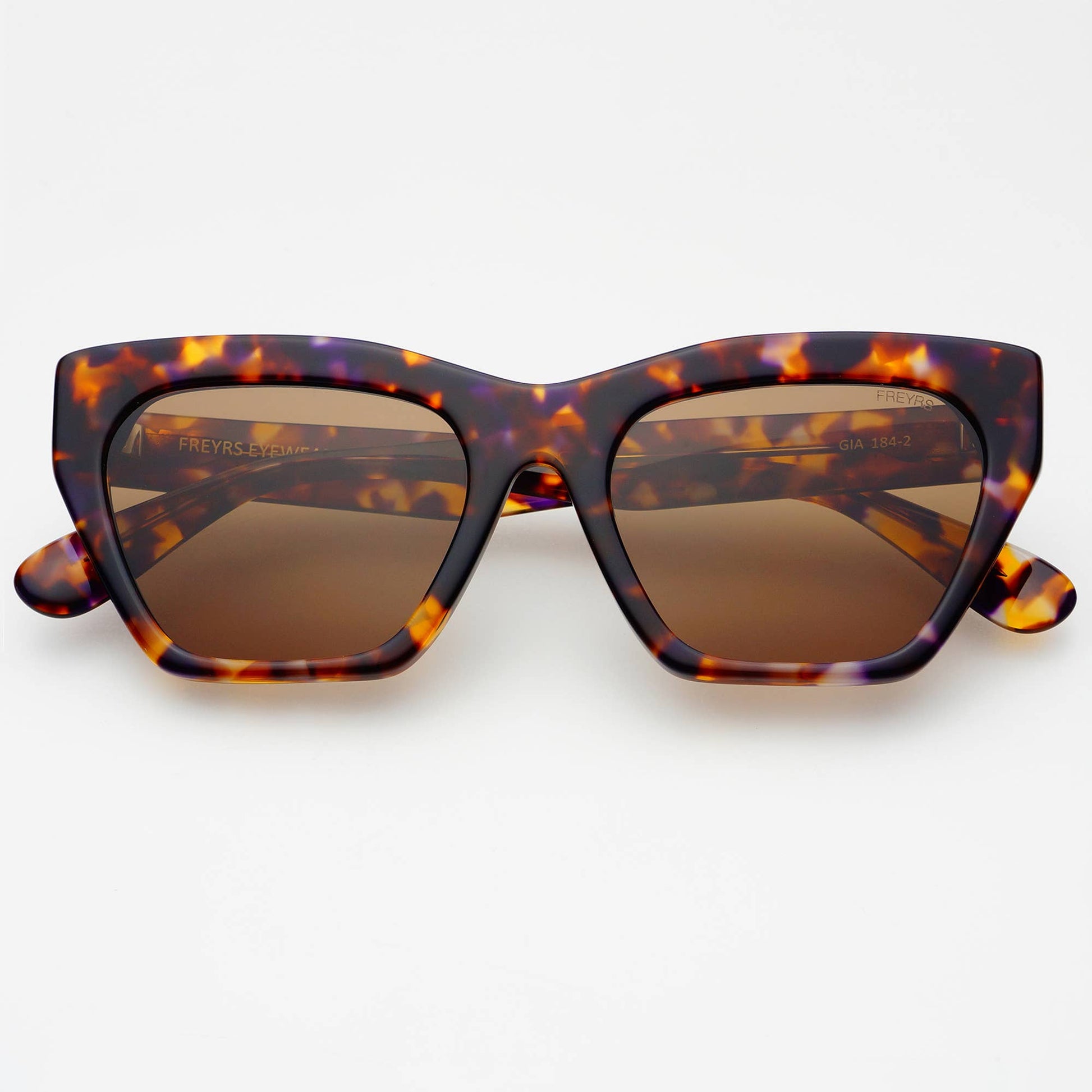 Tortoiseshell sunglasses with brown lenses on a white background