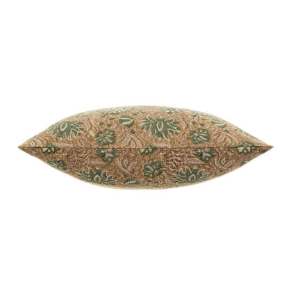 Decorative pillow with green leaf pattern on a beige background