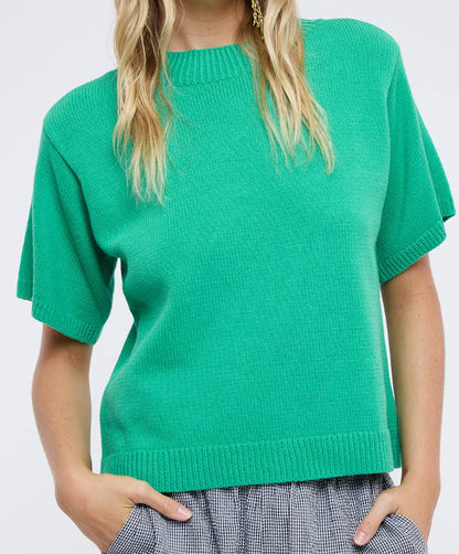 Woman wearing a green sweater against a white background