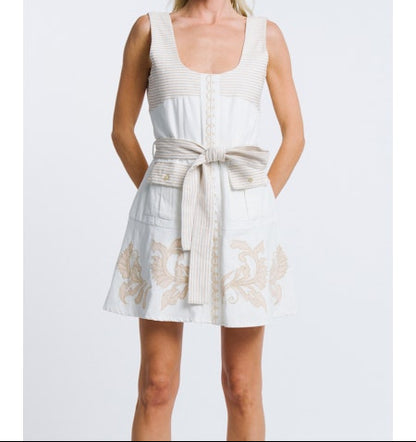 Woman wearing a white dress with floral patterns on a light gray background
