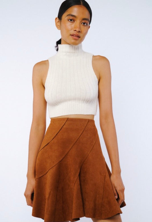 Woman wearing a white sleeveless top and brown skirt on a white background