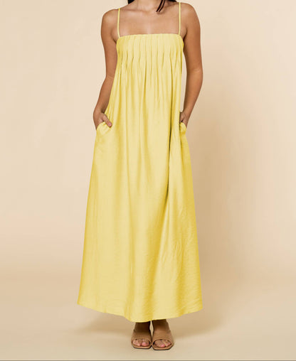 Woman wearing a yellow dress against a beige background