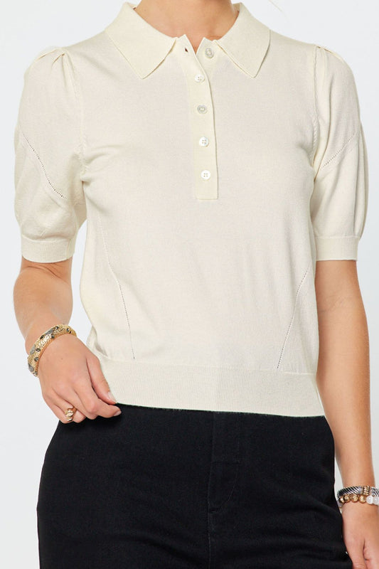 Woman wearing a cream blouse with short sleeves on a white background