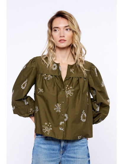Woman wearing an olive green blouse with floral embroidery on a white background