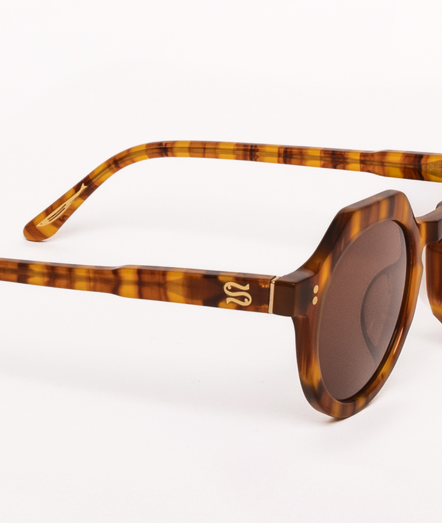 Sunglasses with tortoiseshell frame and brown lenses on a white background