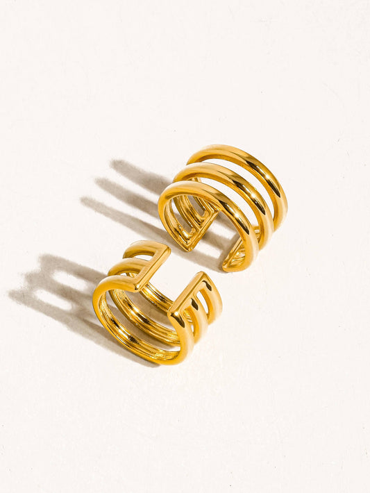 Two gold spiral ear cufffs
 on a white background