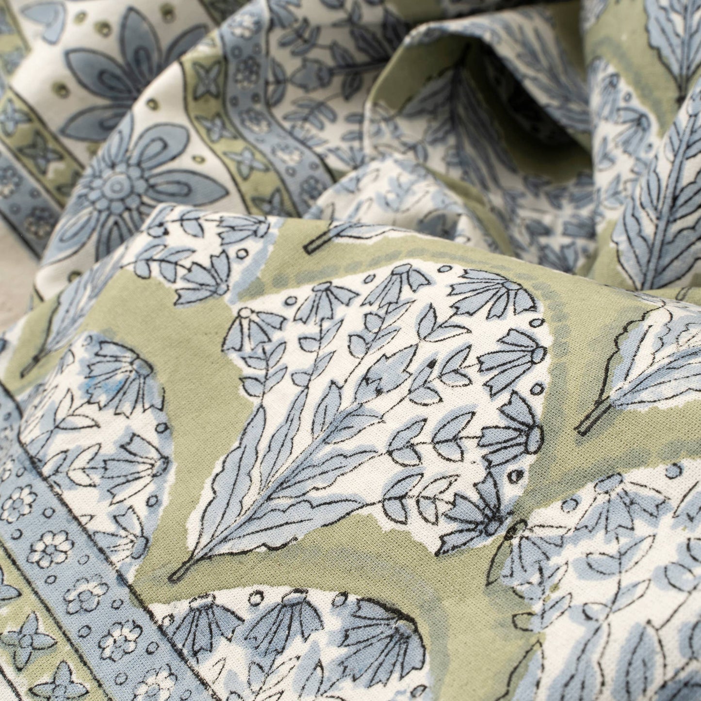 Close-up of fabric with blue floral pattern on a green background