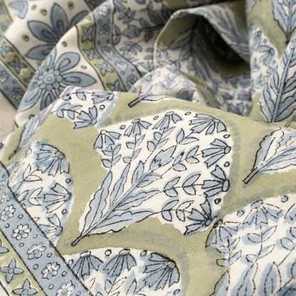Close-up of fabric with blue floral pattern on a green background