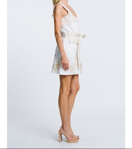 Woman wearing a white dress with thin straps on a light gray background