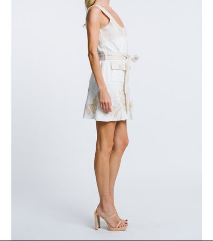 Woman wearing a white dress with thin straps on a light gray background