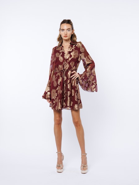 Woman wearing a patterned dress on a white background