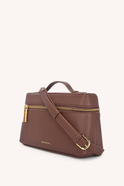 Brown leather handbag with gold zipper and hardware on a white background