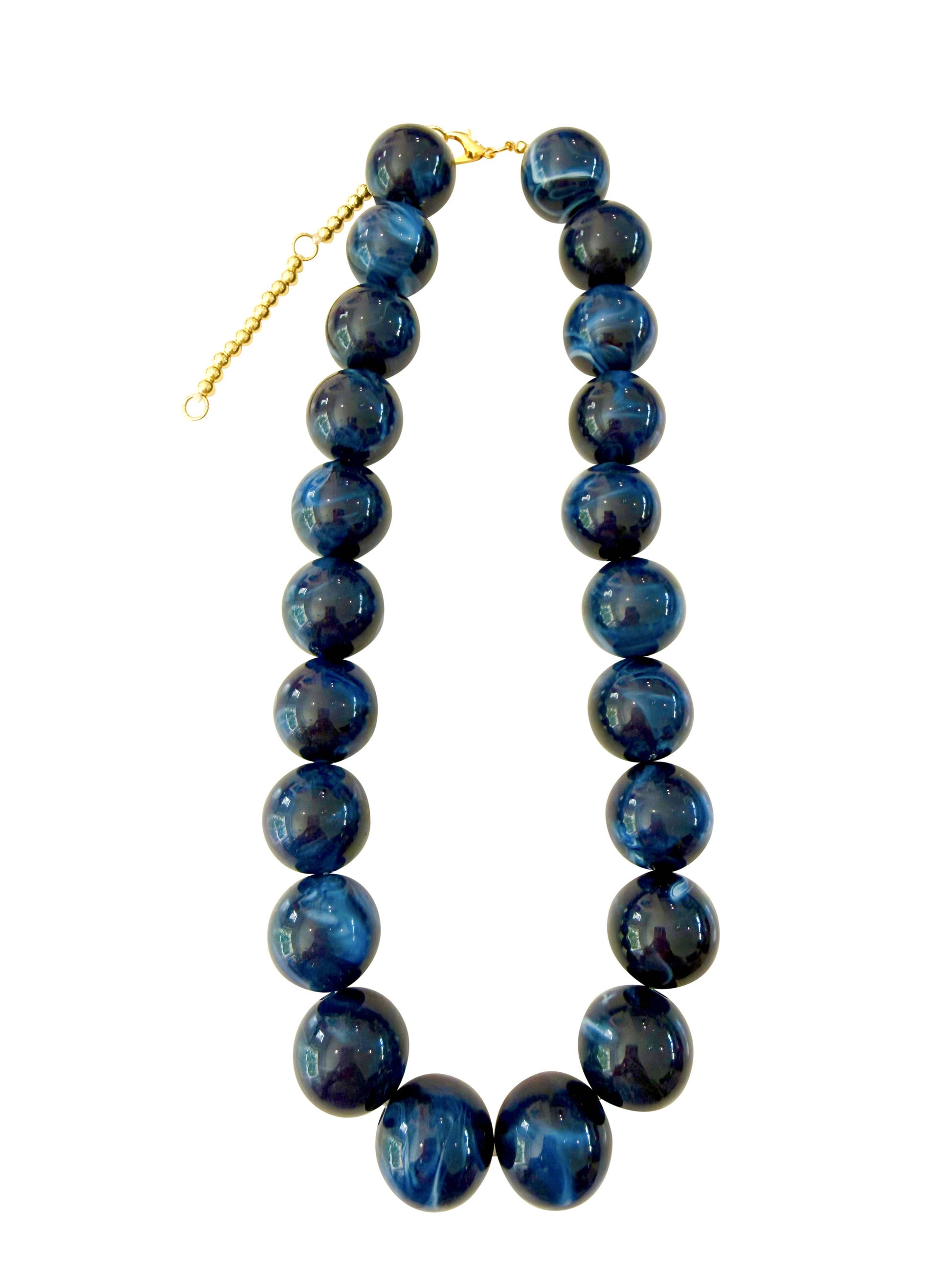 A beaded necklace made of glossy, round dark blue beads with natural marbled patterns, finished with a gold-tone clasp and extender chain, shown on a plain white background.