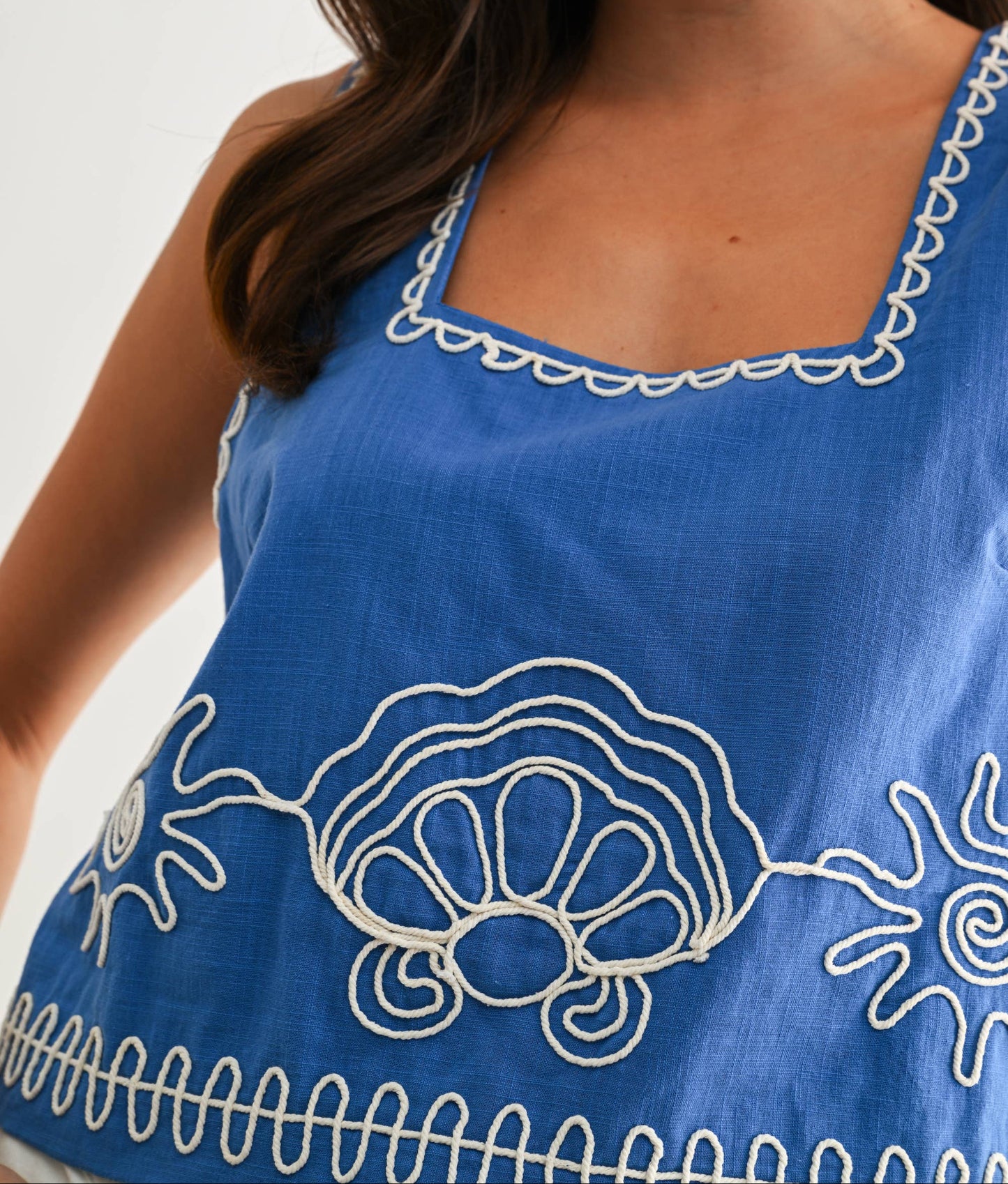 Blue dress with white embroidery on a plain background