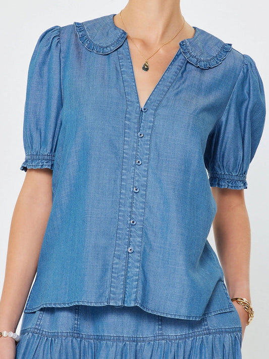 Woman wearing a blue denim blouse and skirt on a white background