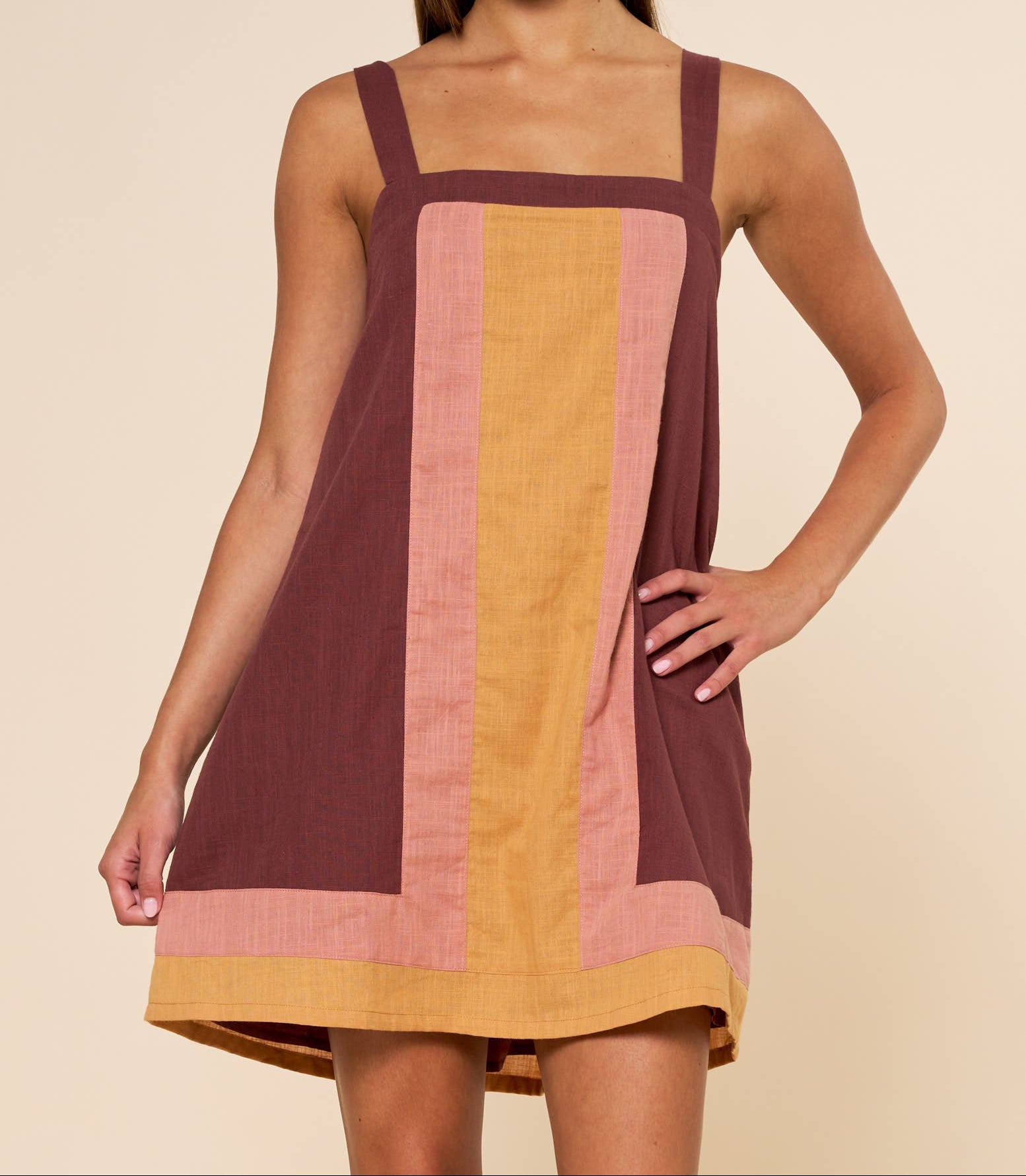 Woman wearing a colorful dress with a plain background