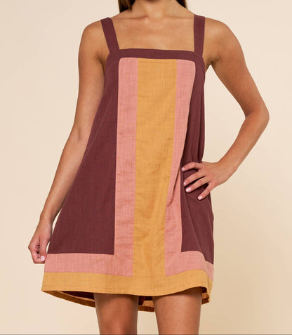 Woman wearing a colorful dress with a plain background
