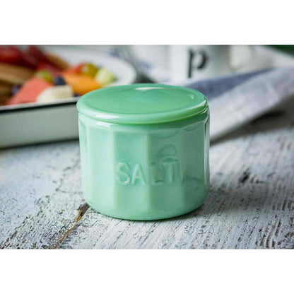 Green salt container on a wooden surface with a blurred background