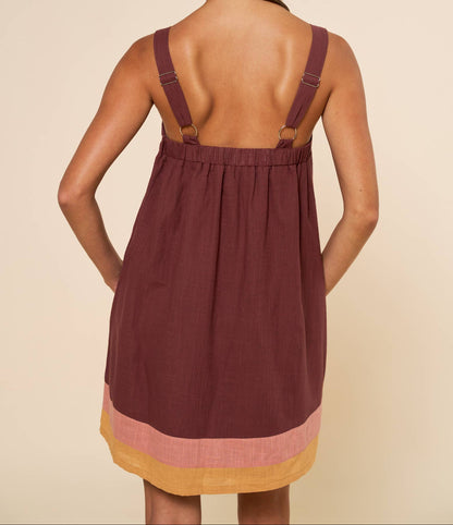 Woman wearing a maroon dress with a beige background