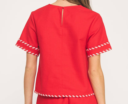 Red outfit with white trim on a plain background